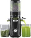 Extractor de zumos ACOQOOS negro en la encimera de una cocina con frutas frescas alrededor